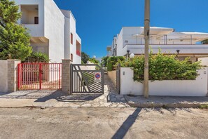 A gated residential area with white buildings, a red gate, and a clear blue sky. - 4194 VSC - Terrazze Sullo Ionio by Barbarhouse (Nardò)