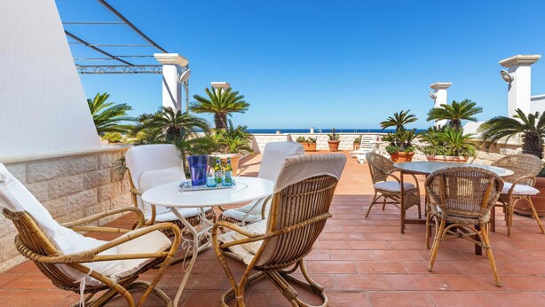 An outdoor patio with wicker furniture, a round table, and potted plants. - 4194 VSC - Terrazze Sullo Ionio by Barbarhouse (Nardò)