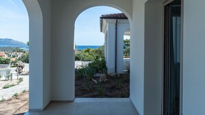 Ein Balkon mit Blick auf das Meer und die Berge.
