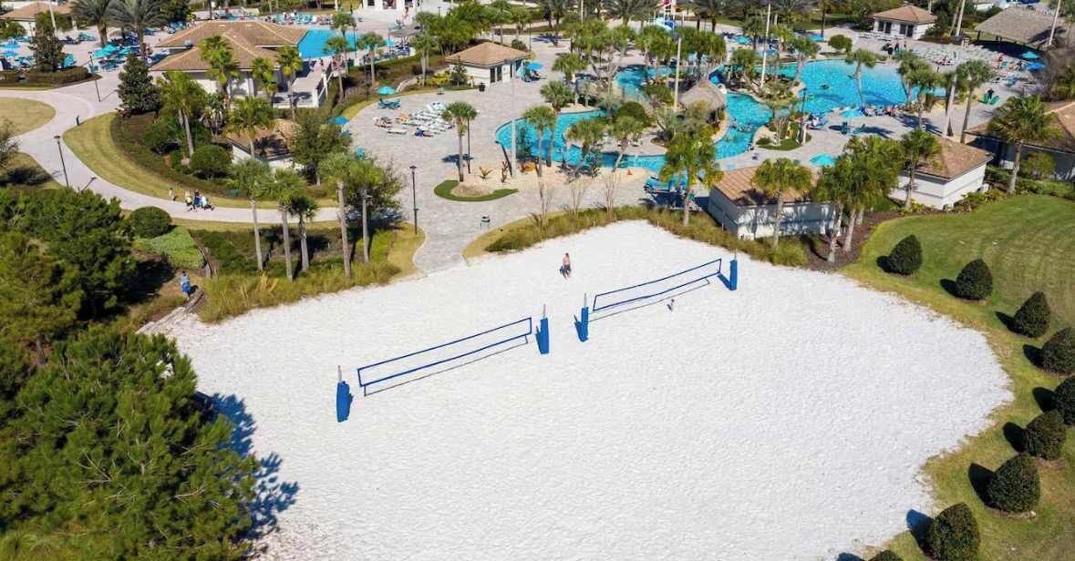 Vista aérea de un resort con múltiples piscinas, una amplia zona de arena y vegetación circundante.