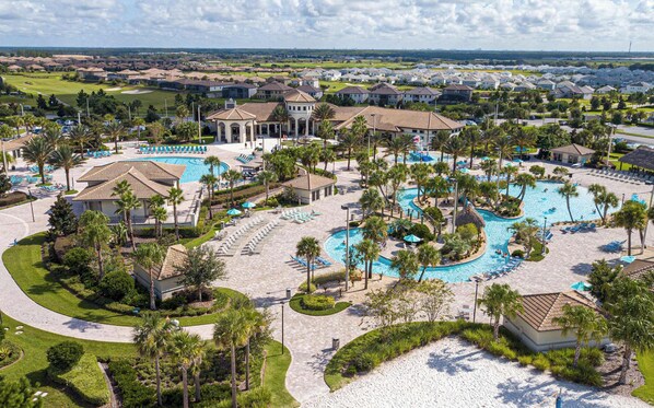 Un complexe hôtelier doté de plusieurs piscines, de palmiers et, au loin, d’un terrain de golf.
