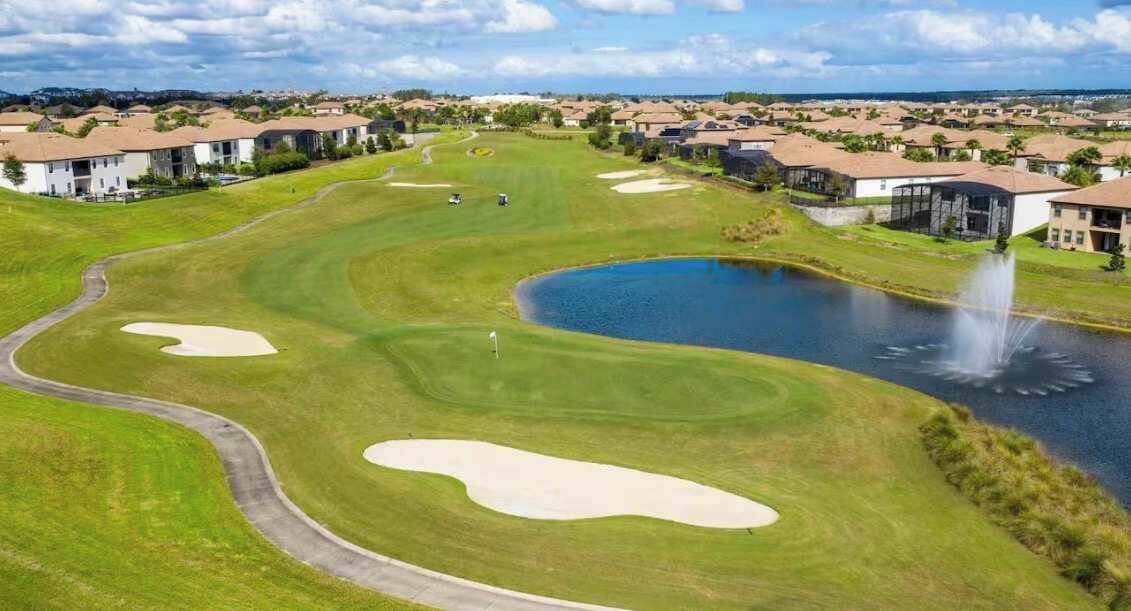 En golfbana med bunkrar, en damm och en fontän.