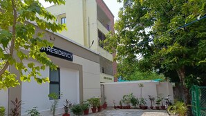 A courtyard with potted plants, a sign reading "RESIDENCY," and a building with balconies. - SM Residency (Bhubaneshwar)