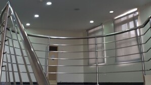 Un intérieur moderne avec un escalier à volutes, des rampes en métal et un éclairage encastré.