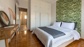 Ein Schlafzimmer mit Bett, Kleiderschrank, Kommode und Spiegel.