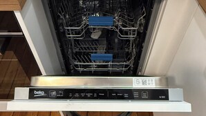 Una cucina con lavastoviglie, piano di lavoro in legno e un asciugamano.