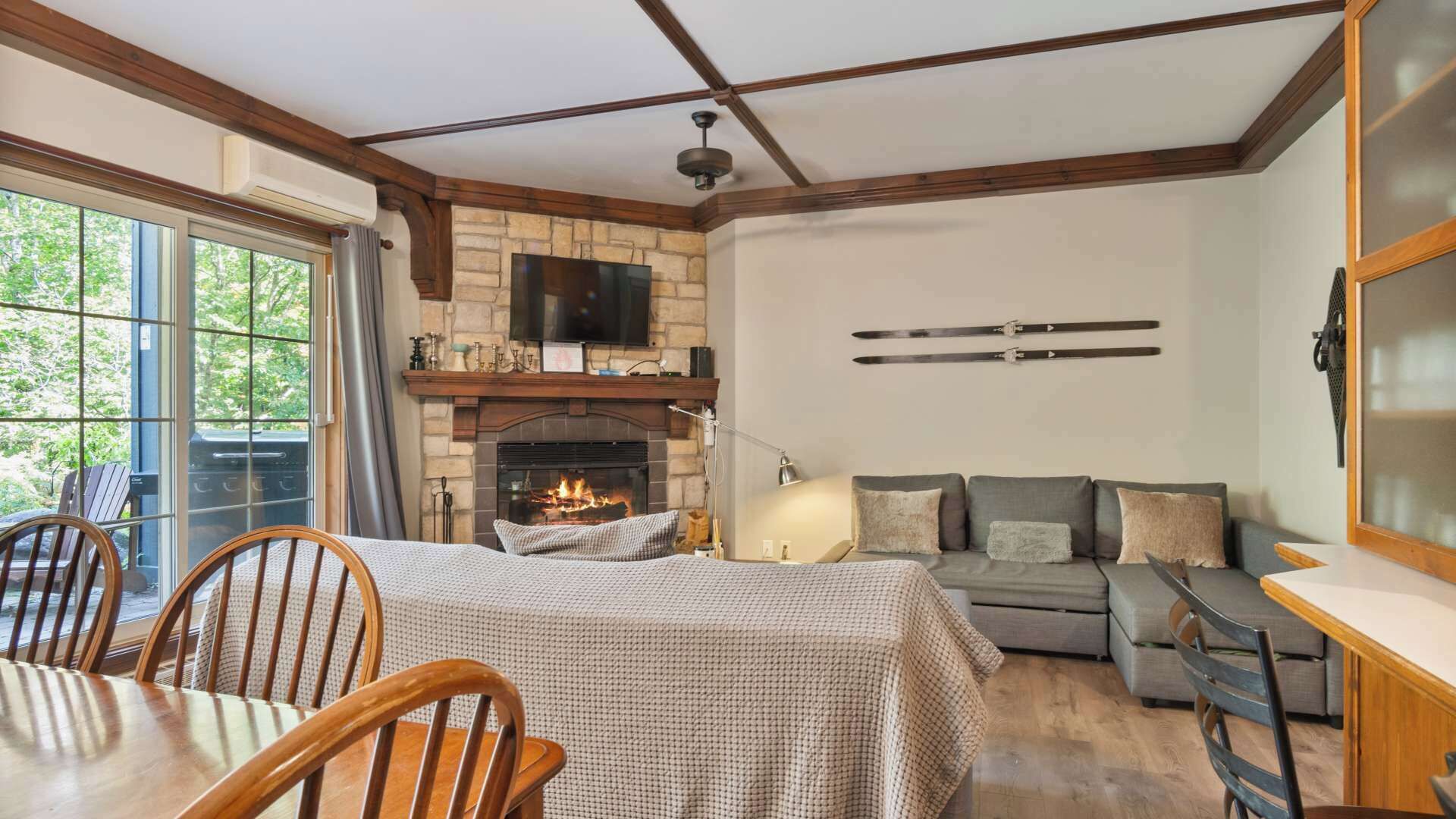 A cozy living room with a fireplace, a sofa, and a dining area with chairs.