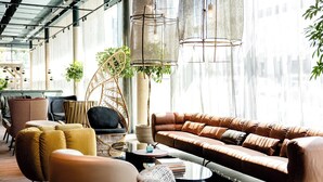 A modern living room with a brown leather sofa, yellow armchairs, and wicker furniture. - Motel One Paris - Porte de Versailles (Issy-les-Moulineaux)