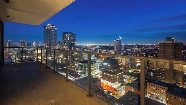 A balcony with a city view at dusk. - Tower Views! Pool, FREE Banff Pass! (Calgary)