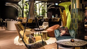 Eine moderne Lounge-Ecke mit Hängekorbschaukel, Sofas und einem kleinen runden Tisch.
