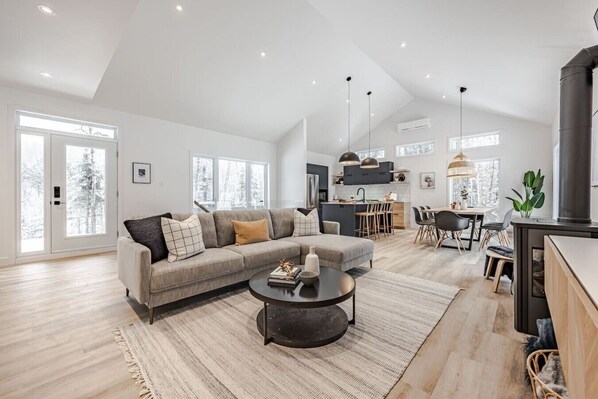 A spacious living room with a sofa, coffee table, and dining area.