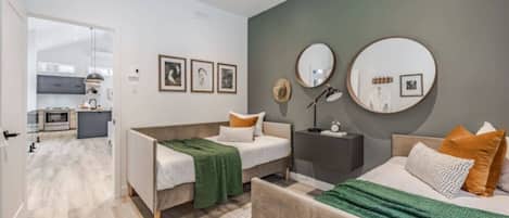 A modern bedroom with a double bed, a bedside table, a nightstand, and a wall-mounted mirror.