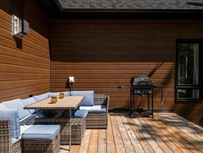 An outdoor patio with a dining set and a grill. - Private Hot Tub | Hiking | Skiing | Roitelet (Argenteuil Regional County Municipality)