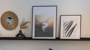 A neatly made bed with a book, pillows, and a framed picture above it. - Private Spa| Hiking| Skiing| Mini Chalet| Assinie (Brownsburg)