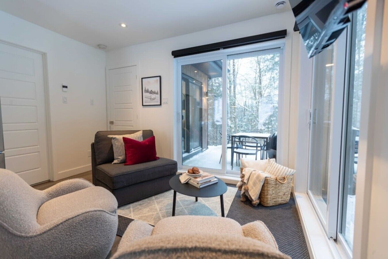Una sala de estar moderna con un sofá, sillones, una mesa de centro y un comedor con mesa y sillas.
