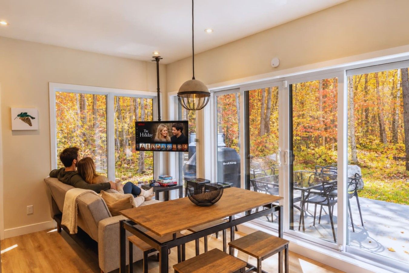 A cozy living room with a sofa and a TV displaying 'The Holiday'.