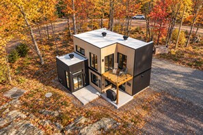 Una moderna casa a due piani con un balcone, ampie finestre e un garage.