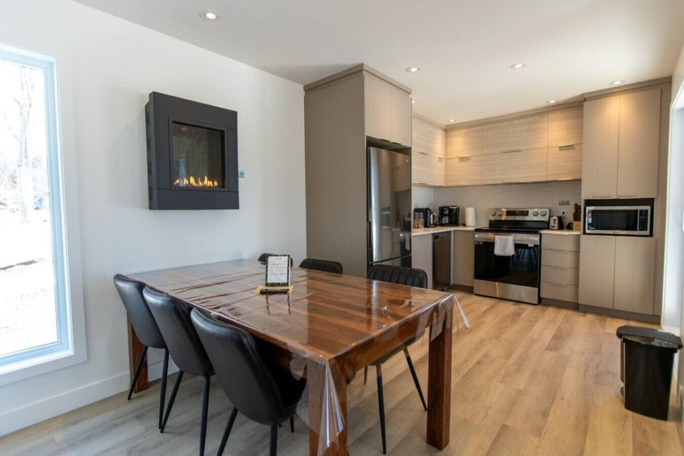 Una cocina moderna con comedor, electrodomésticos integrados y chimenea.