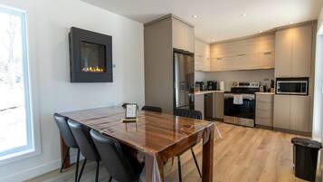 Una cocina moderna con comedor, electrodomésticos integrados y chimenea.