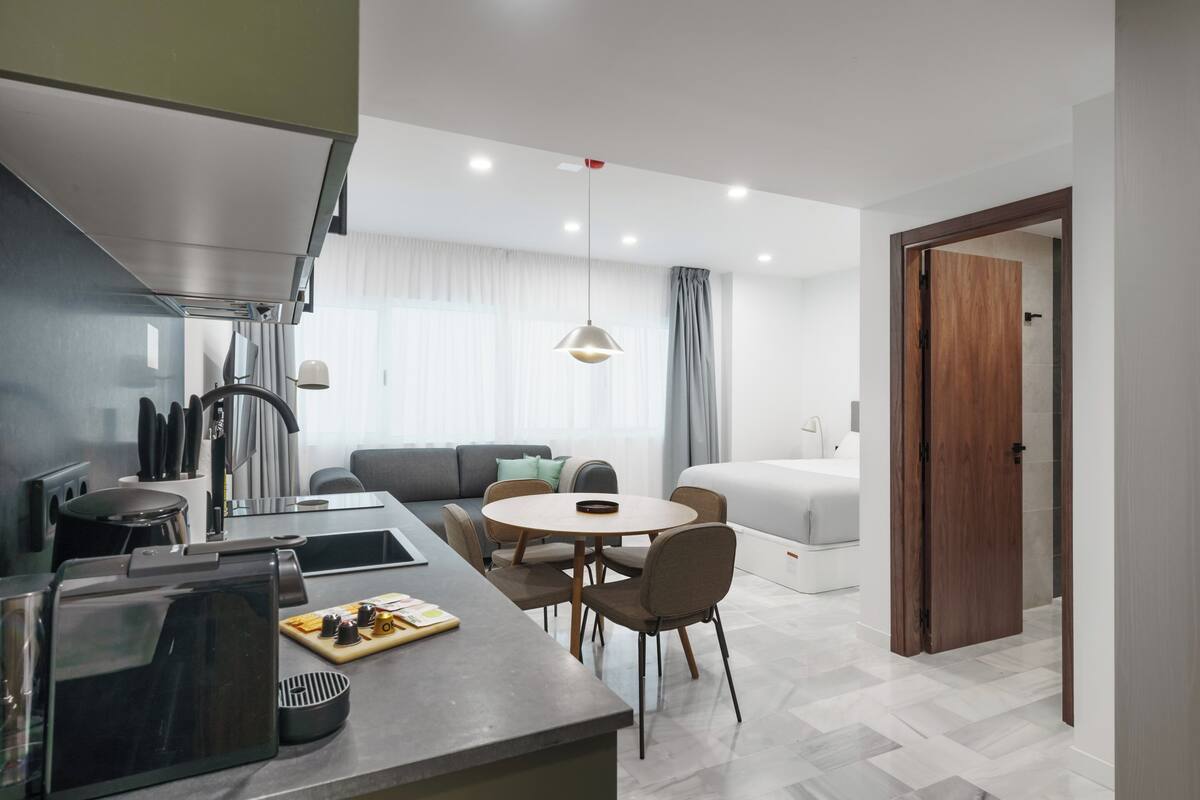 Una cocina moderna con comedor, sofá y puerta de madera.