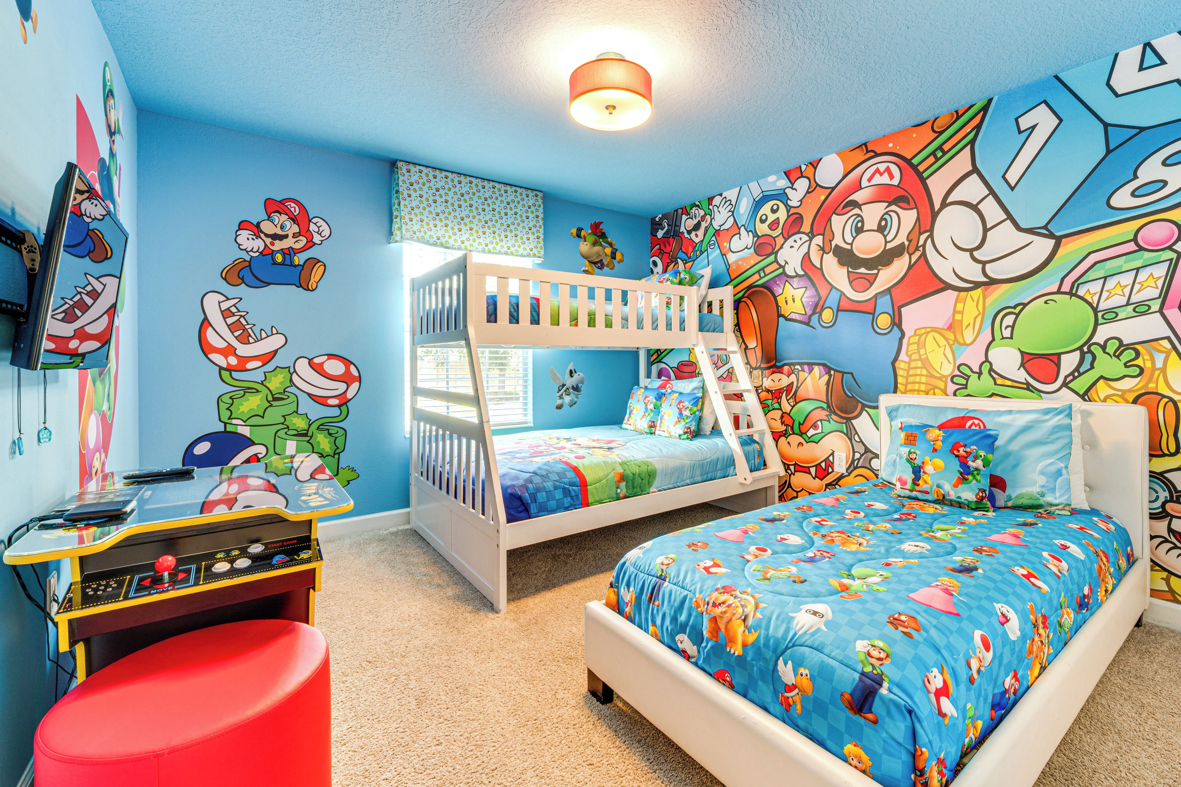 A child's bedroom with a bunk bed, a desk, and a colorful Mario-themed mural.