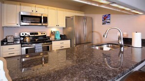 A kitchen with stainless steel appliances, a granite countertop, and a stainless steel sink. - The Evergreen. Hot tub, grill, walk to slopes. (Crested Butte)