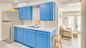 A modern kitchen with blue cabinets, a stainless steel refrigerator, and a white countertop. - 1 Mi to Dtwn: Home w/ Furnished Patio in Pensacola (Pensacola)