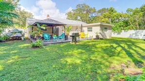 A house with a covered patio, outdoor furniture, and a well-maintained lawn. - 5 Mi to Vero Beach: Vintage Home w/ Sauna & Grill! (Vero Beach)