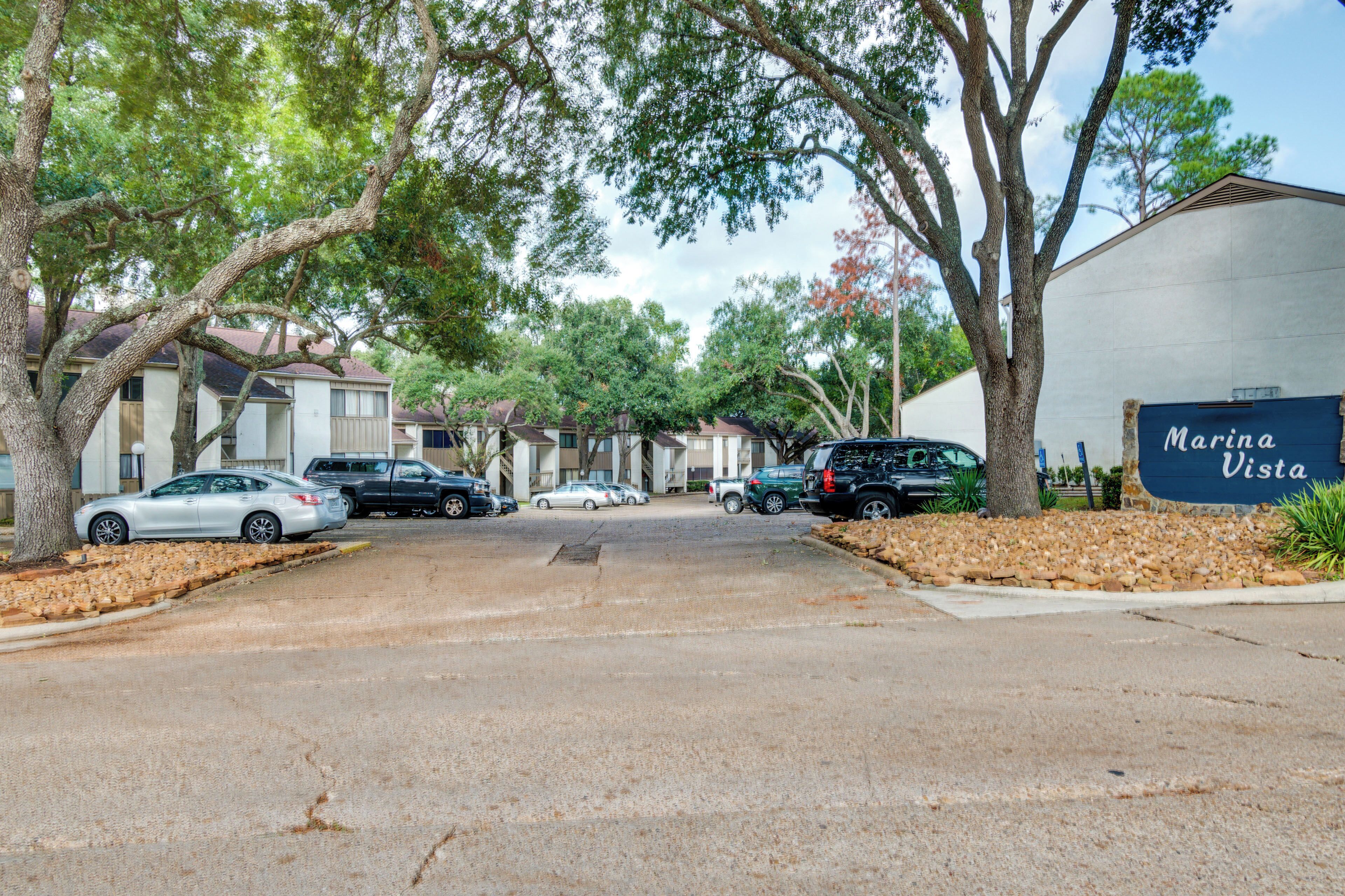 A residential street with parked cars, trees, and a building labeled "Marina Vista."
