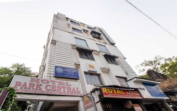 Hotel Park Central features a prominent sign with address and contact information, set against a backdrop of windows and balconies.