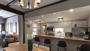 Una cocina moderna con una isla central, electrodomésticos de acero inoxidable y un letrero que dice 'WELCOME'.