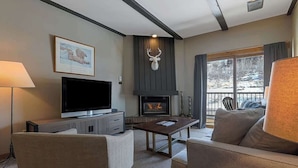 Una sala de estar moderna con chimenea, televisor y asientos cómodos.