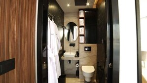 Une salle de bain moderne avec un meuble-lavabo en bois, un miroir, des toilettes et un lavabo.
