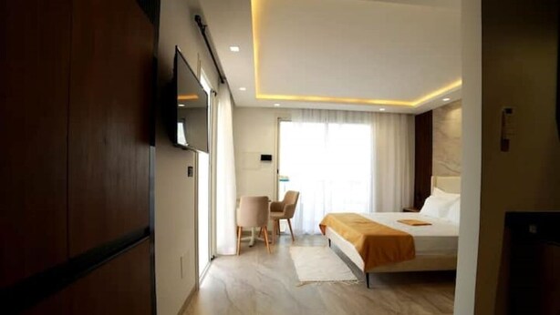 Une chambre d’hôtel avec un lit, un bureau et une télévision.