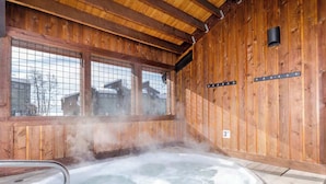 A wooden interior with a hot tub, large windows, and a visible 3ft sign. - Gondola Village Chalet (Steamboat Springs)