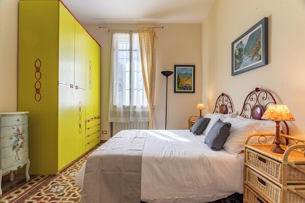 A bedroom with a bed, a nightstand, a lamp, a dresser, and a wardrobe. - 100 m² Downtown Apartment for Up to 8 Guests + Free Private Parking (Verona)