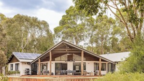 Uma casa moderna com varanda coberta, janelas amplas e painéis solares.