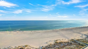 Une plage avec un ciel dégagé et une mer calme.