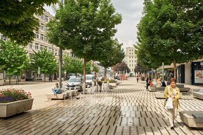 A paved pedestrian area with benches and a fountain. - SERENITY Residence (Poznan)