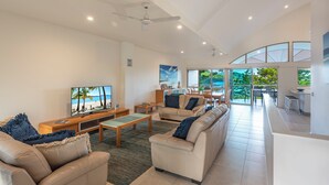 Un espacio habitable amplio con un televisor grande, asientos cómodos y vistas al exterior.