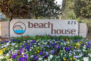 A beach house sign with a water icon and the number 675. - Beach House 401d 1 Bedroom Condo (Miramar Beach)