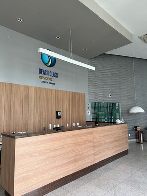 A reception desk with a logo for 'Beach Class Residence Santa Maria'. - Flat no Beach Class Santa Maria (Recife)