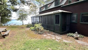 A two-story house with a covered porch and a view of the water. - A Sense Of Place Limit 17 7 Bedroom Villa (Sebago)