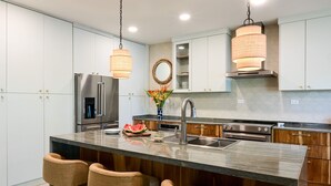 A modern kitchen with a central island, stainless steel appliances, and pendant lighting. - Esterillos Lote 6 Bedroom Home (Parrita)