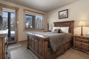 A bedroom with a bed, wooden dresser, and a window with a mountain view. - Antler At Lakota 407 3 Bedroom Home (Winter Park)