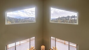A room with two large windows offering views of a forested landscape. - Quinn Creek Chalet-Great home to relax with family & enjoy the views! (Bozeman)