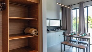 A modern kitchen with wooden cabinetry and a dining area with a table set for four.