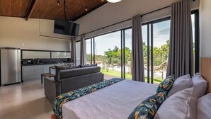 Un dormitorio moderno con una cama grande, un sofá y una zona de cocina.