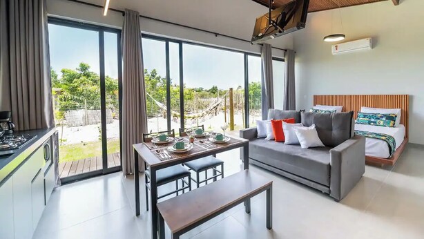 Una habitación moderna con sofá, mesa de comedor y zona de cocina.