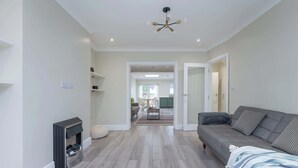 Una sala de estar moderna con chimenea, un sofá y un comedor al fondo.